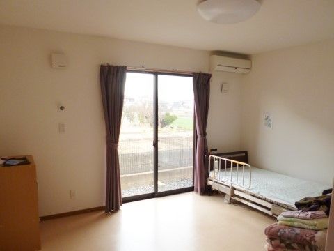 掃き出し窓の外はバルコニー。介護ベッドと小家具を置いても十分な空きスペースがある個室