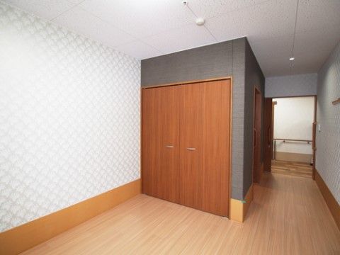 おしゃれな模様の白い壁紙、一角は黒い壁紙がアクセントのモダンな雰囲気の個室