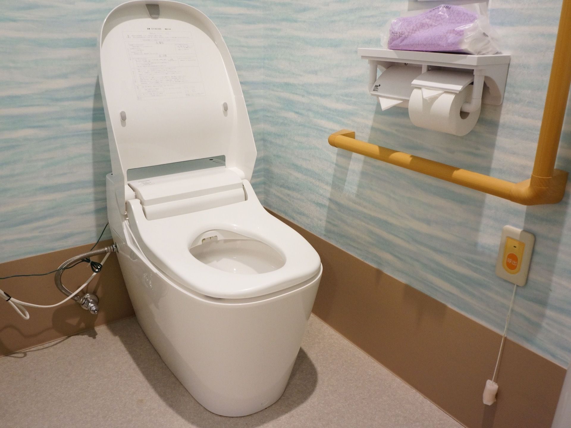 トイレの壁は水色になっており明るい雰囲気である。トイレットペーパーホルダーの上にはペーパータオルを置くことができ便利である。