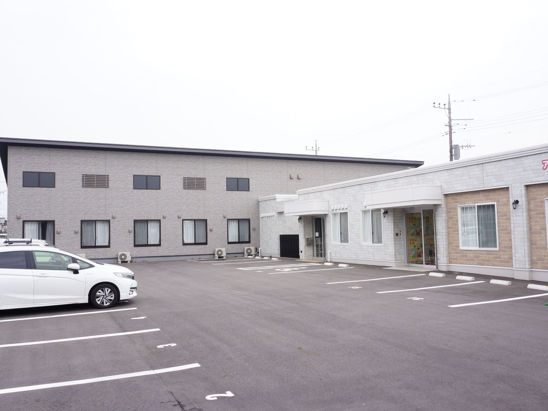 レンガ調のオシャレな外観になっている。施設の前には駐車場があり広々としている。玄関の扉はガラス張りである。