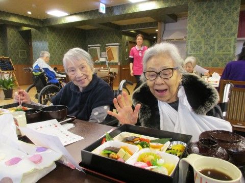 広い食堂の中でお重に入った弁当を前に嬉しそうな入所者