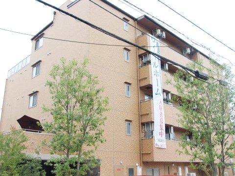マンションのような佇まいをしたデザインなので、ご自宅と同じような感覚でご利用いただける。施設名が書かれたのぼりが掲示されている。