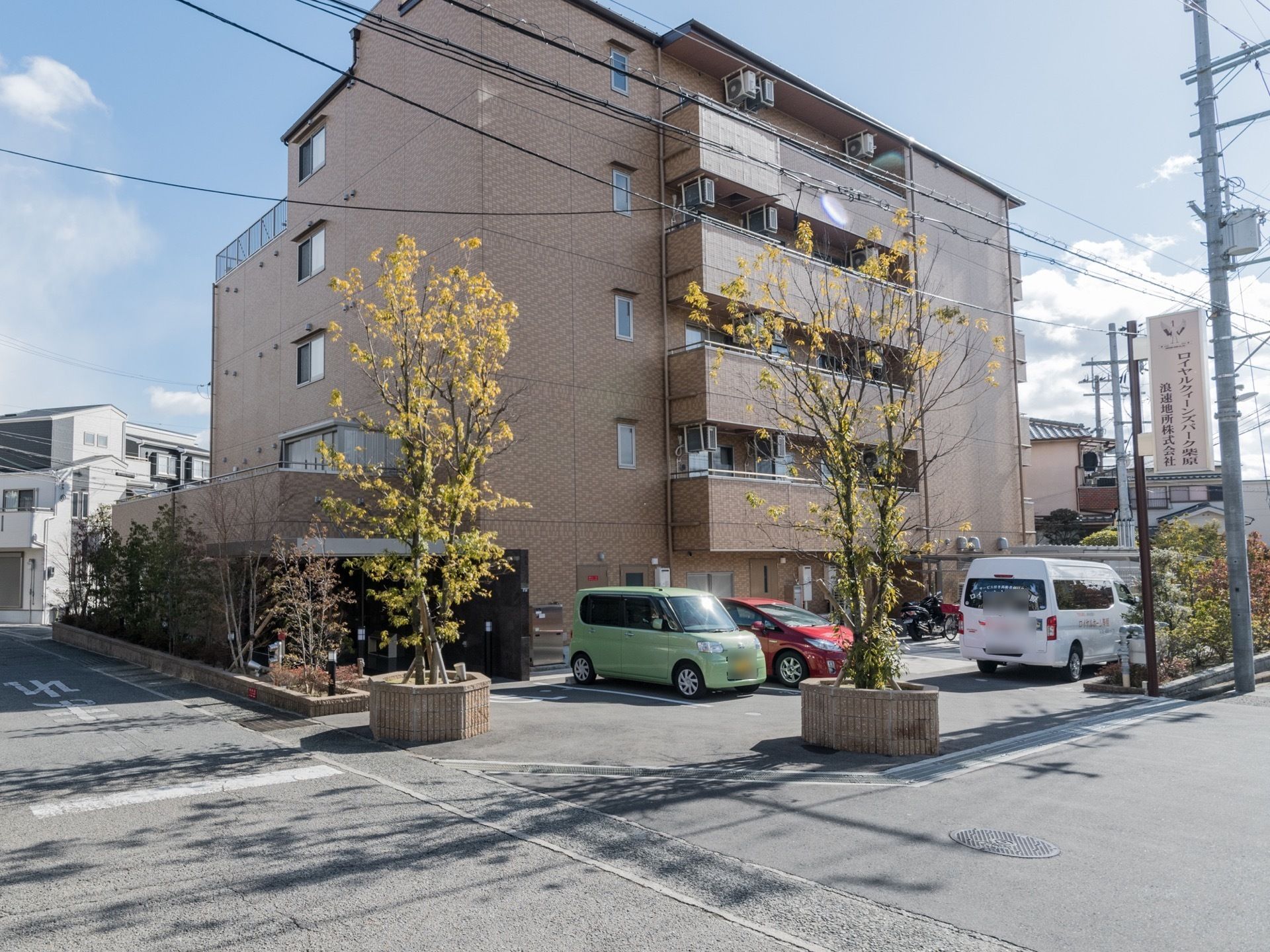 綺麗な5階建てのマンションのような建物がこちらの施設。数台の車やバイクが停められる駐車場も併設されている。