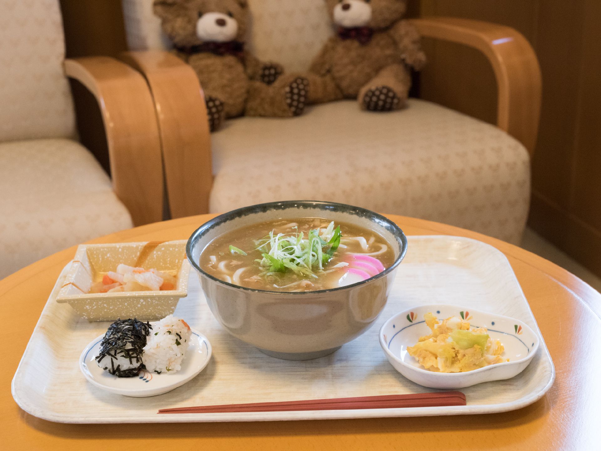 ネギとかまぼこの乗ったうどんと、おにぎりのお食事。