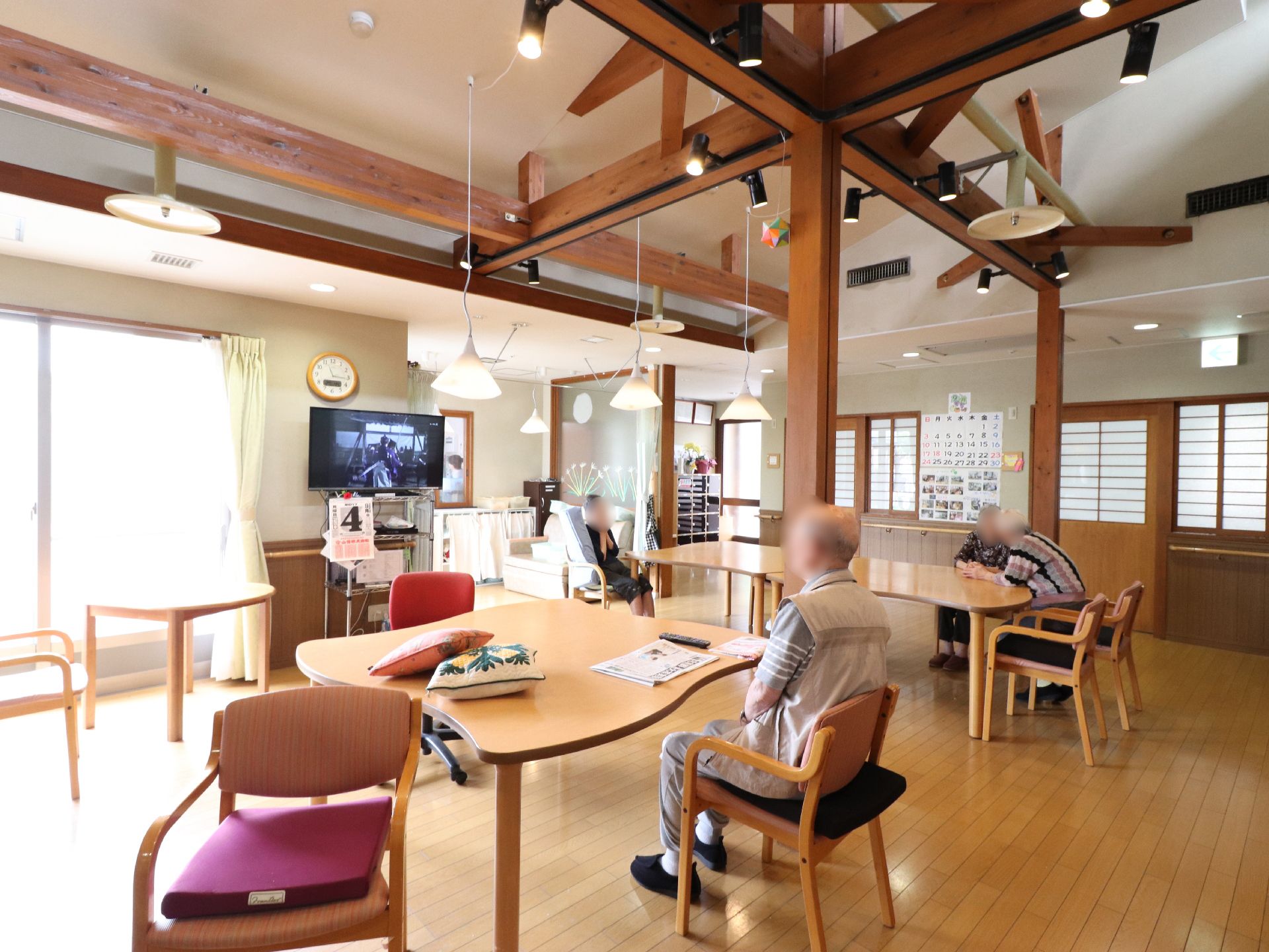 玄関を入ると食堂が広がっている。勾配天井に見せ梁が使われている。梁にはスポットライト、天井にペンダントライトが設置されている。