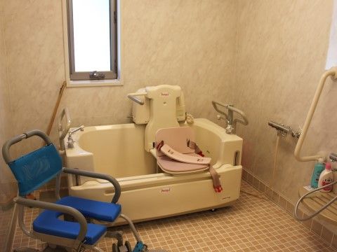 車椅子をご利用の方でも、座位で入浴可能な介護浴槽が設置されている。シャワーチェアーも設置されている。