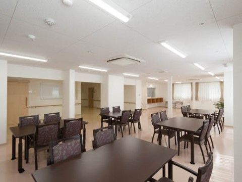 こげ茶色の4人掛けテーブルと椅子が規則正しく並ぶ広い空間