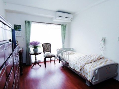 「介護付有料老人ホーム花咲」床色が美しい居室に大きなマドとベッド。