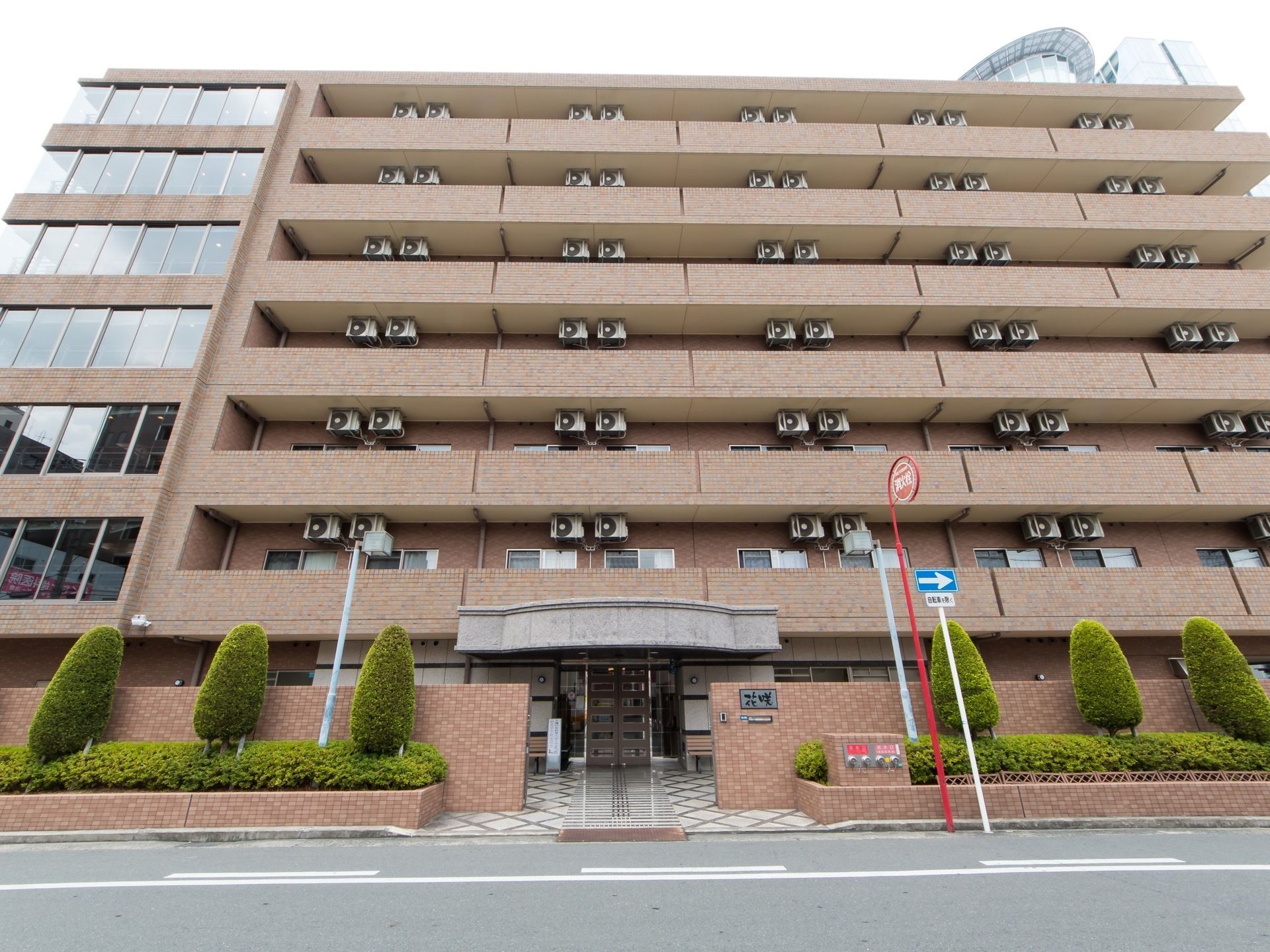茶色のレンガ積み模様を基調とした７階建ての建物である。施設前にある歩道沿いに、消火栓が設置されている。
