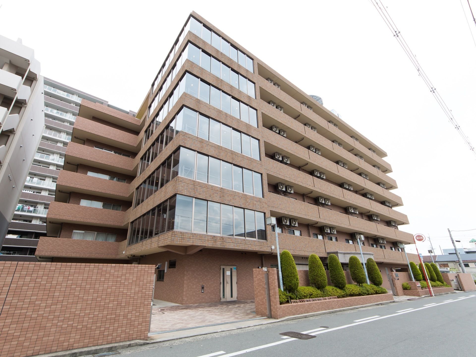 道路に面して立地している７階建ての施設である。２階から上のコーナー部は、２面に窓を設けた構造になっている。