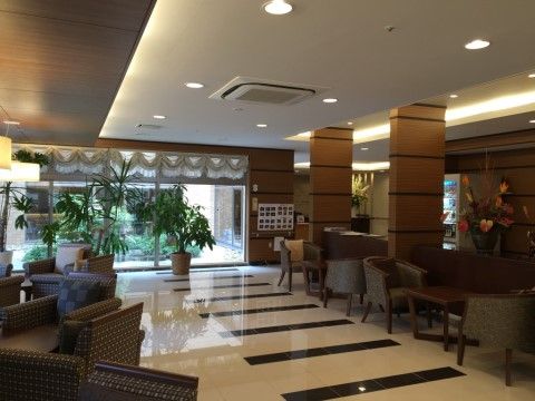 ソファーや椅子などが置かれ、シックなインテリアで統一されている。大きな観葉植物や、アレンジメントされた花などが飾られている。