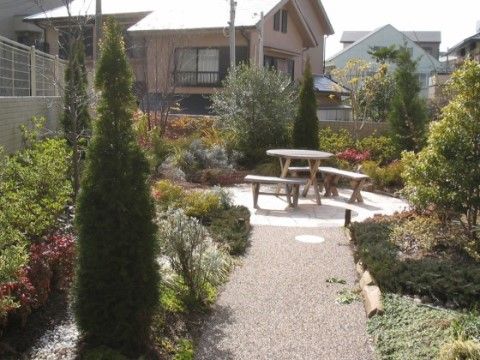 植物がたくさん植えられ、手入れの行き届いた庭になっている。木製のテーブルとベンチが備えられ、ゆっくりと過ごせる空間になっている。