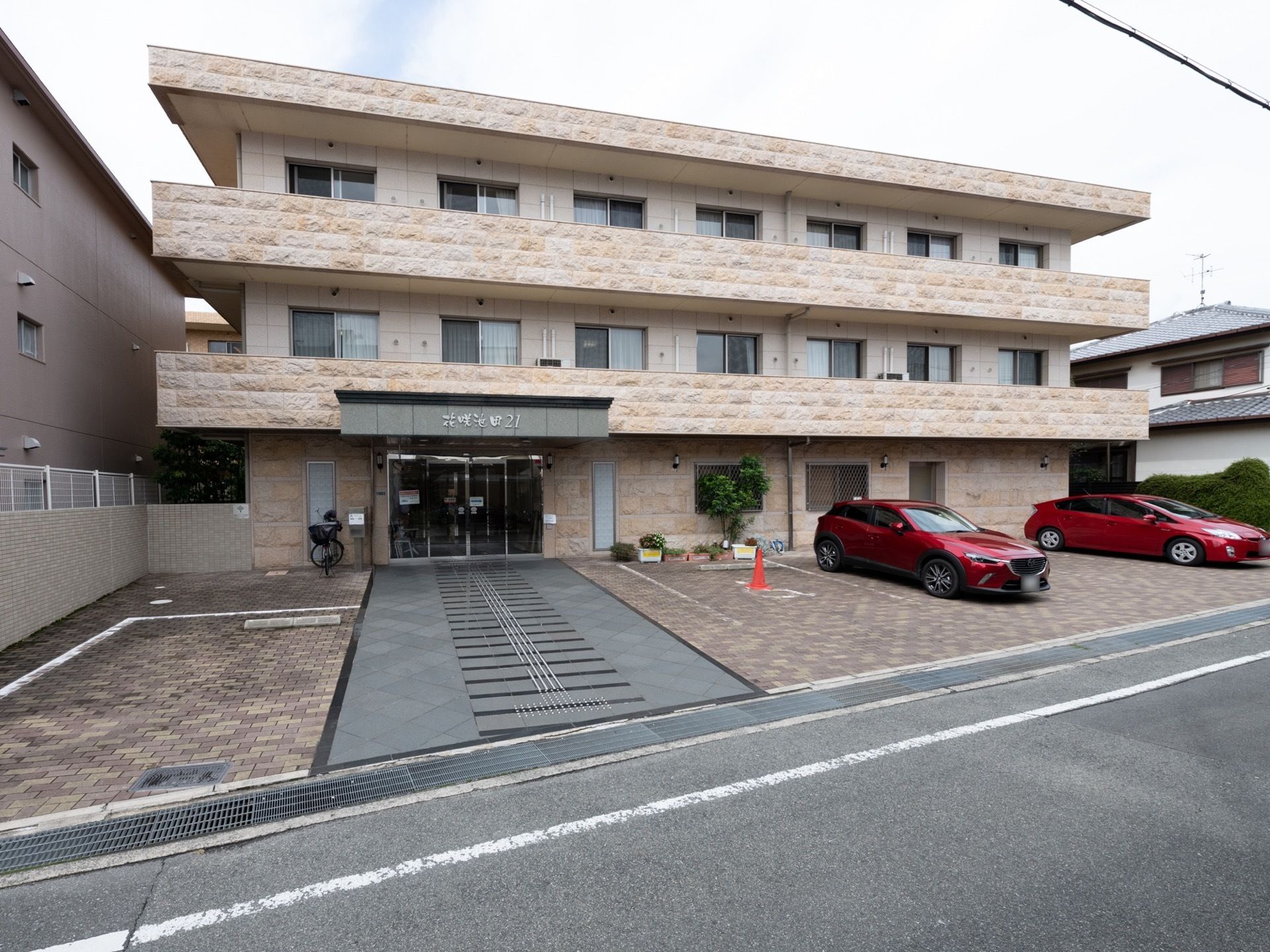 ３階建てのマンションタイプの施設。駐車スペースも複数台ある。近隣は閑静な住宅街で、駅近な施設になっている。