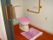 居室内のトイレは広いスペースを確保している。入口が大きな引き戸になっており出入りしやすく、Ｌ字の手すりも設置され、安全に利用できる。