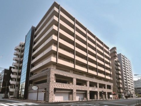 青空の下に建つ、高級感のあるマンションのような外観の建物。４階から９階までの縦にのびるラインがセンスの良さを感じさせる。