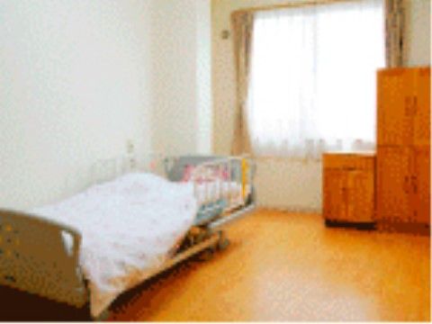 介護用ベッドが置かれた居室で、窓からは日が入り明るい雰囲気である。空いたスペースには愛用の家具などを持ち込むことができる。