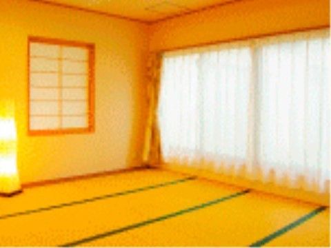カーテンのついた大きな窓と障子と間接照明のある畳張りの和室