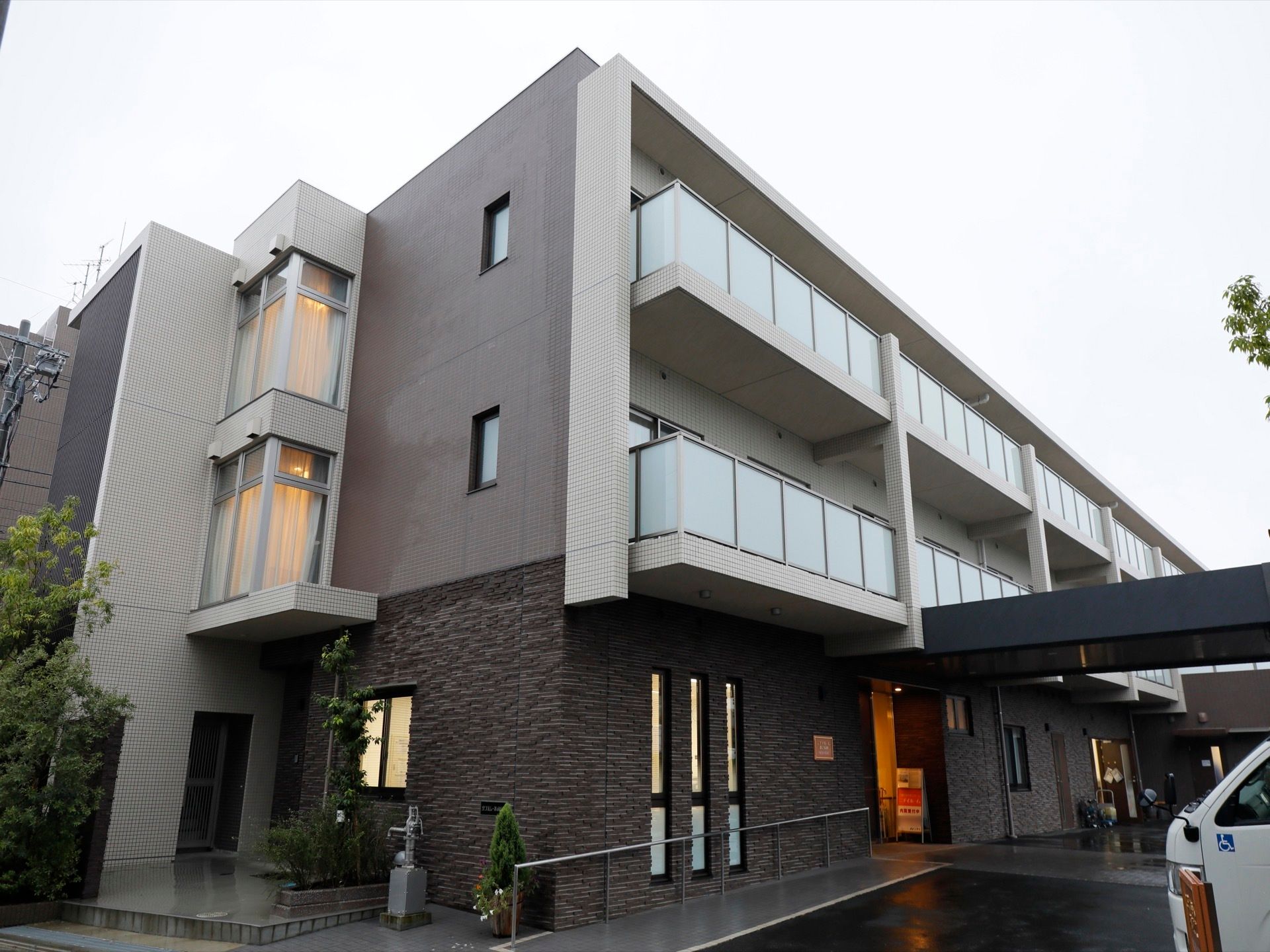 グレーのシックな外観の施設は高級なマンション風な見た目である。都心にありながら、穏やかで緑に囲まれて生活ができる。