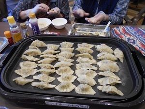 ホットプレートで餃子をたくさん焼く様子