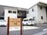 建物の前に駐車場があり、その入り口に施設名の書かれた看板が立っている。黒の文字がはっきりしていてとても読みやすい。
