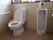 床と壁にタイルが貼られたトイレの図である。左側に温水洗浄便座が設置されたトイレがあり、右側に男性用トイレがある。