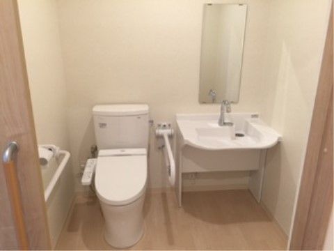 明るい色調で統一されたトイレである。幅の広い手洗い場の下は障害物がなく、車椅子に乗ったまま利用しやすい設計。