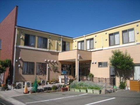 「ライフハーモニー堺なかもず」の外観。緑に囲まれた優しい雰囲気の建物。