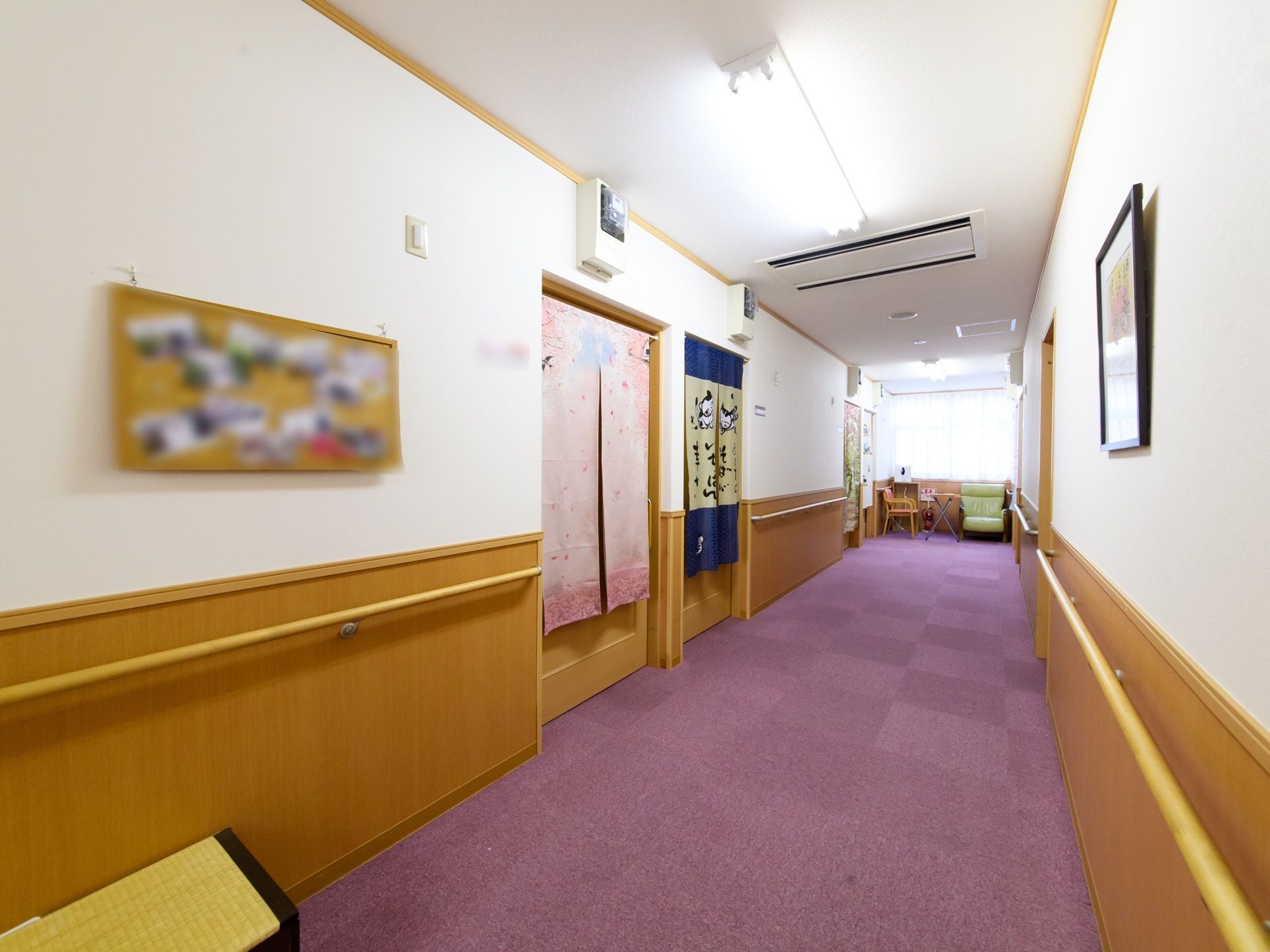 通路には絨毯が敷き詰められている。両壁に手すりが付いていて、エアコンも設置されている。写真などの掲示物が飾られた、明るい通路である。