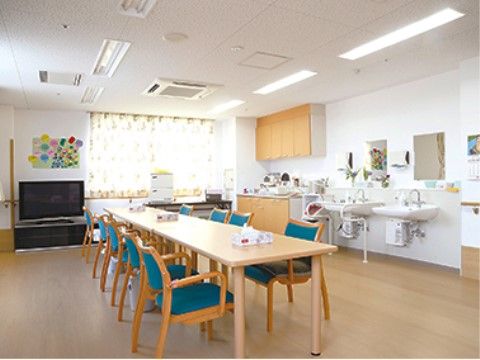 室内にはテーブル、手すり付きの椅子、大型テレビが置かれている。大きな窓があり、洗面設備が設けられている。