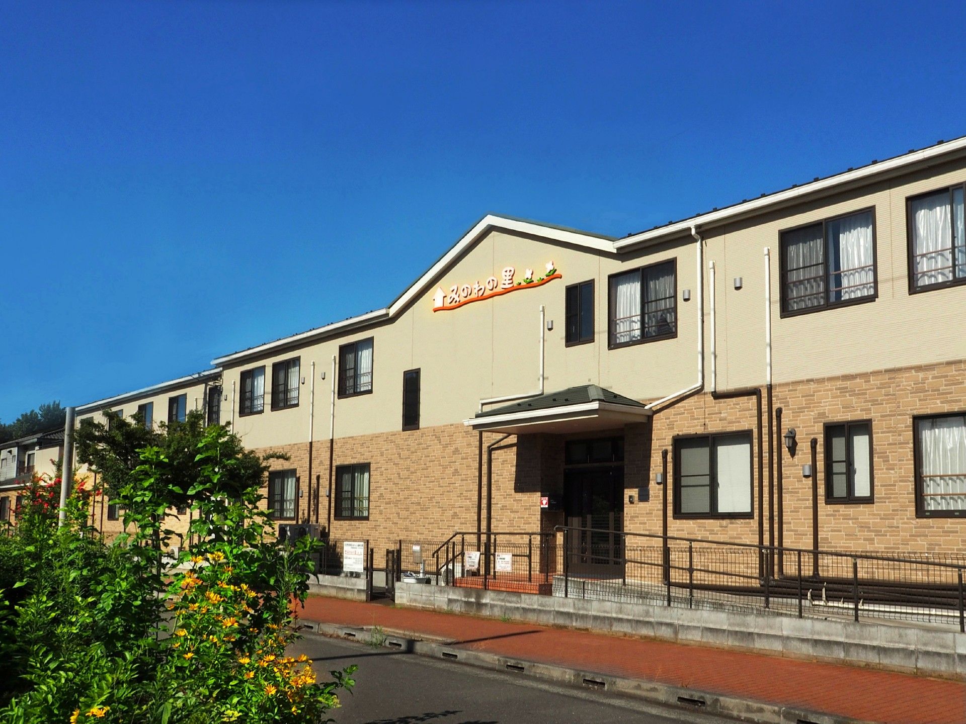 入口にスロープのある三角屋根が特徴的な２階建ての建物