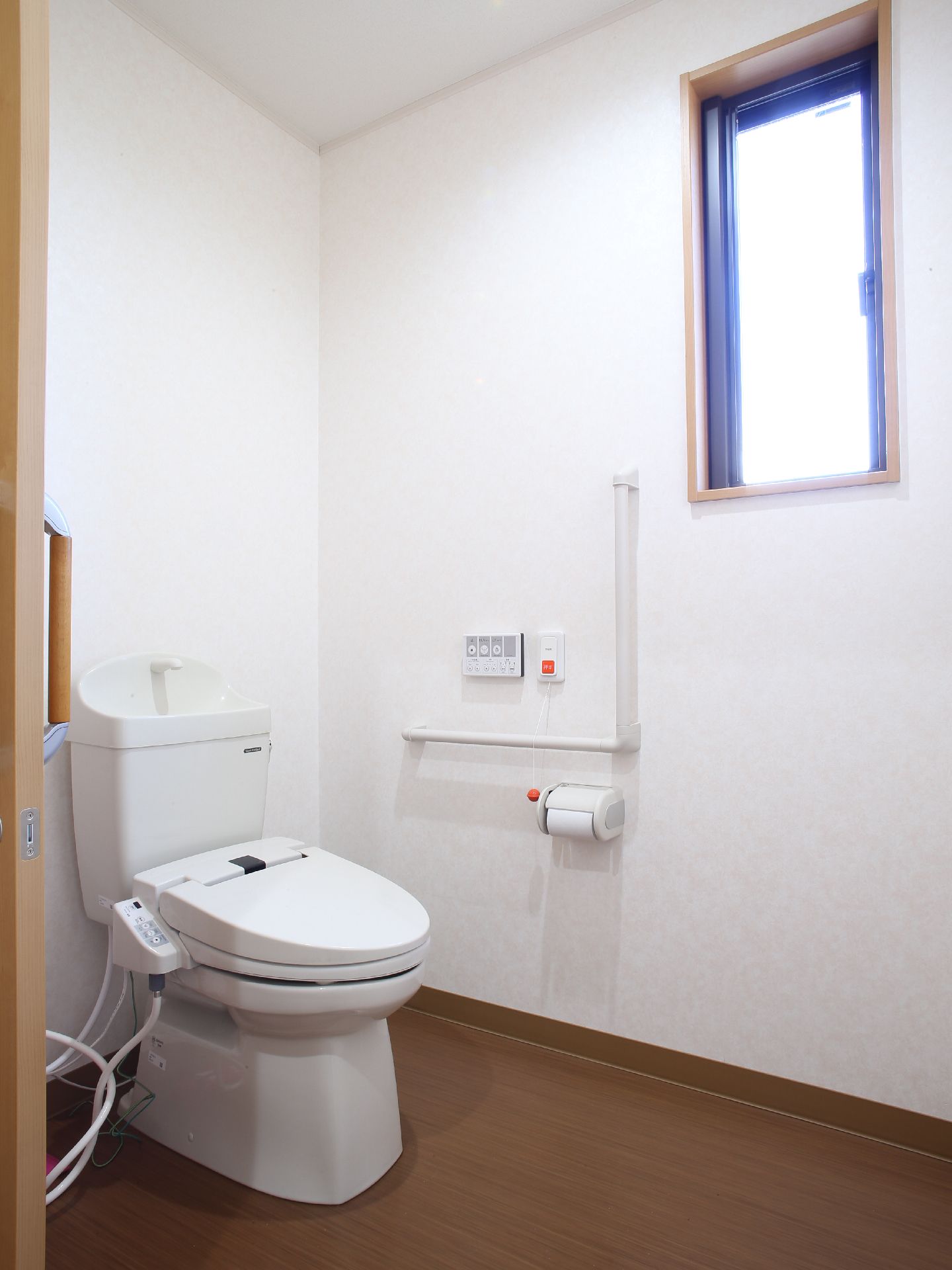 トイレは広々としており車いすでの乗り入れが可能。しっかりとしたL字型の手すりと緊急呼び出しボタンが付いているので安心。