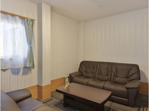 2つの3人掛けソファーが低いテーブルを挟んで向い合せに置かれている個室。テーブルの上には飾り時計が置かれている。