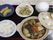 鍋を主菜とした食事の一例。お盆の上には、ごはんと野菜、肉、とうふなどが入った土鍋、野菜の和え物の小鉢と果物がのっている。
