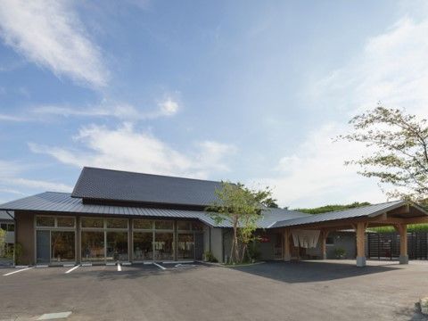 駐車場が隣接され、和風の屋根付きのアプローチが備えられた、平屋建ての施設
