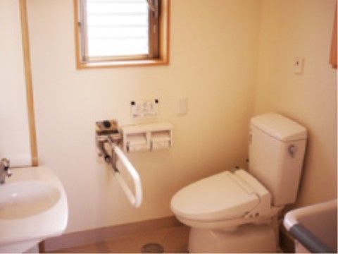 窓があり、明るく清潔感のあるトイレである。温水洗浄便座になっており、快適に利用することができ、操作ボタンは壁にある。