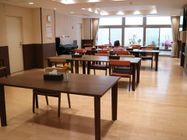 食堂兼共有スペースは、床が全面光沢のないフローリング張りになっている。部屋の隅にはイベントなどに使えるアップライトピアノがある。