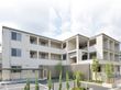 3階建ての白い建物と駐車場