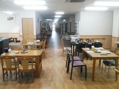 ４人掛けのテーブルが用意されている。部屋の隅には畳のスペースがあり、座布団と丸テーブルが置かれている。