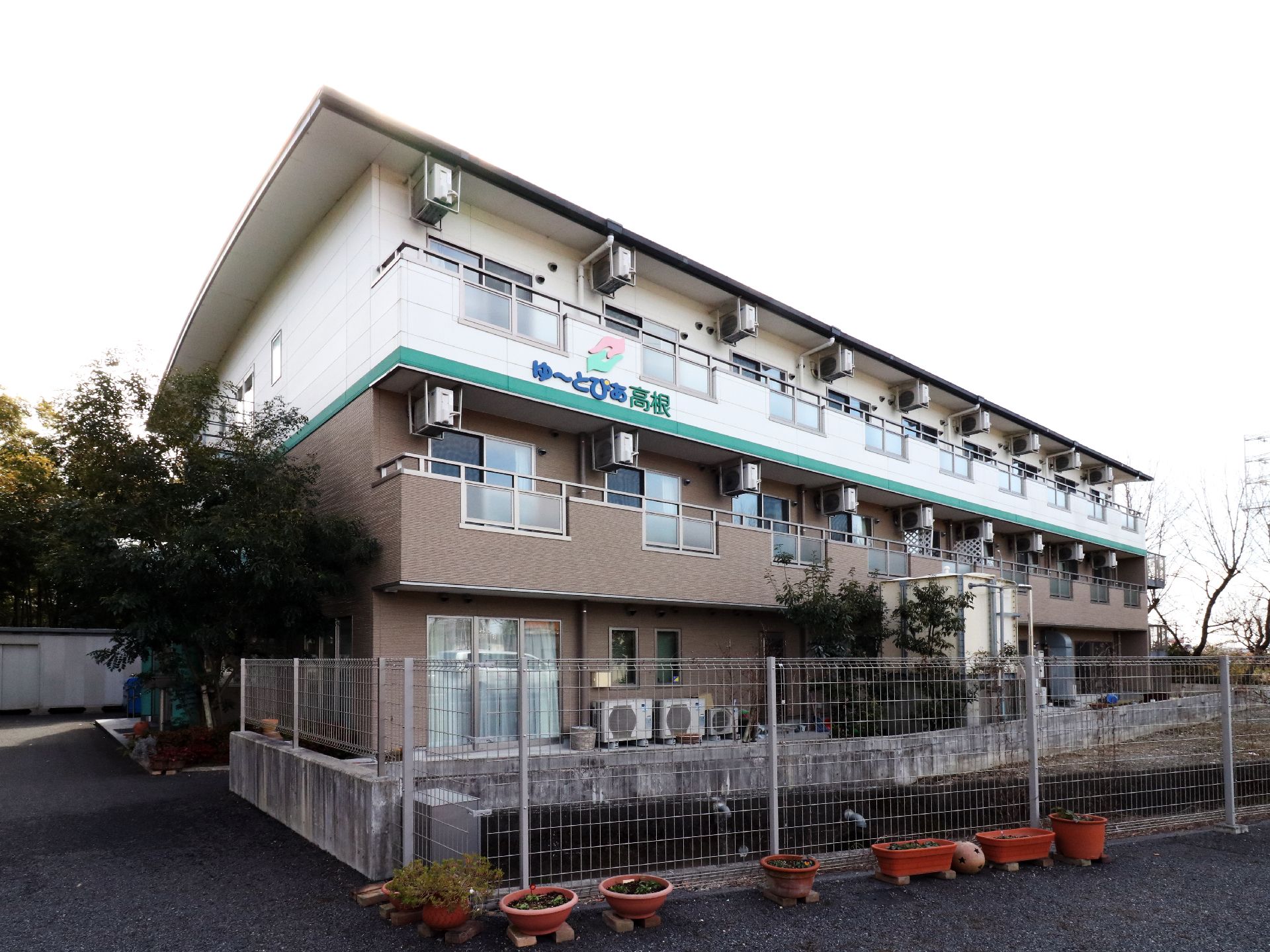 ３階建ての建物で、１階２階はタイル張りで、３階は白い塗装のマンションのような外観
