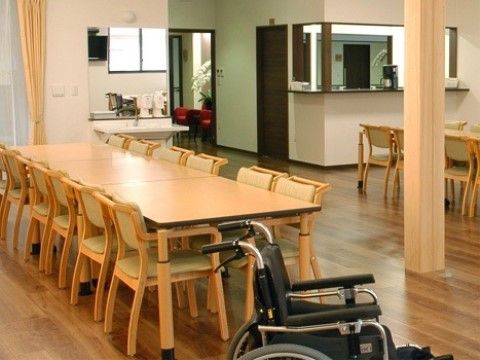 机と椅子が並んでいる広々とした場所で、手前には車いすが置いてある室内