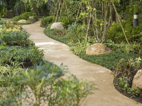 ゆるやかにカーブしながら道が続いており、両側にさまざまな植物が植えられている。ところどころに大きな石が置かれている。