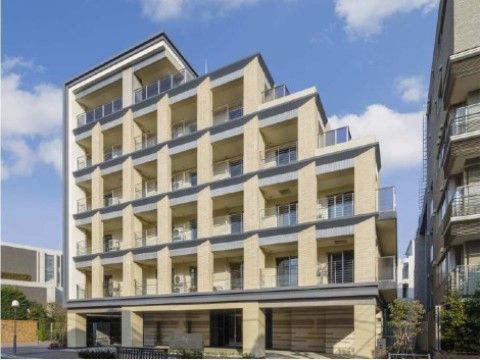 おしゃれな外観で、ベージュを基調に建物の縁やベランダは紺色に塗られている。１階の正面には大きな柱が所々に造られている。
