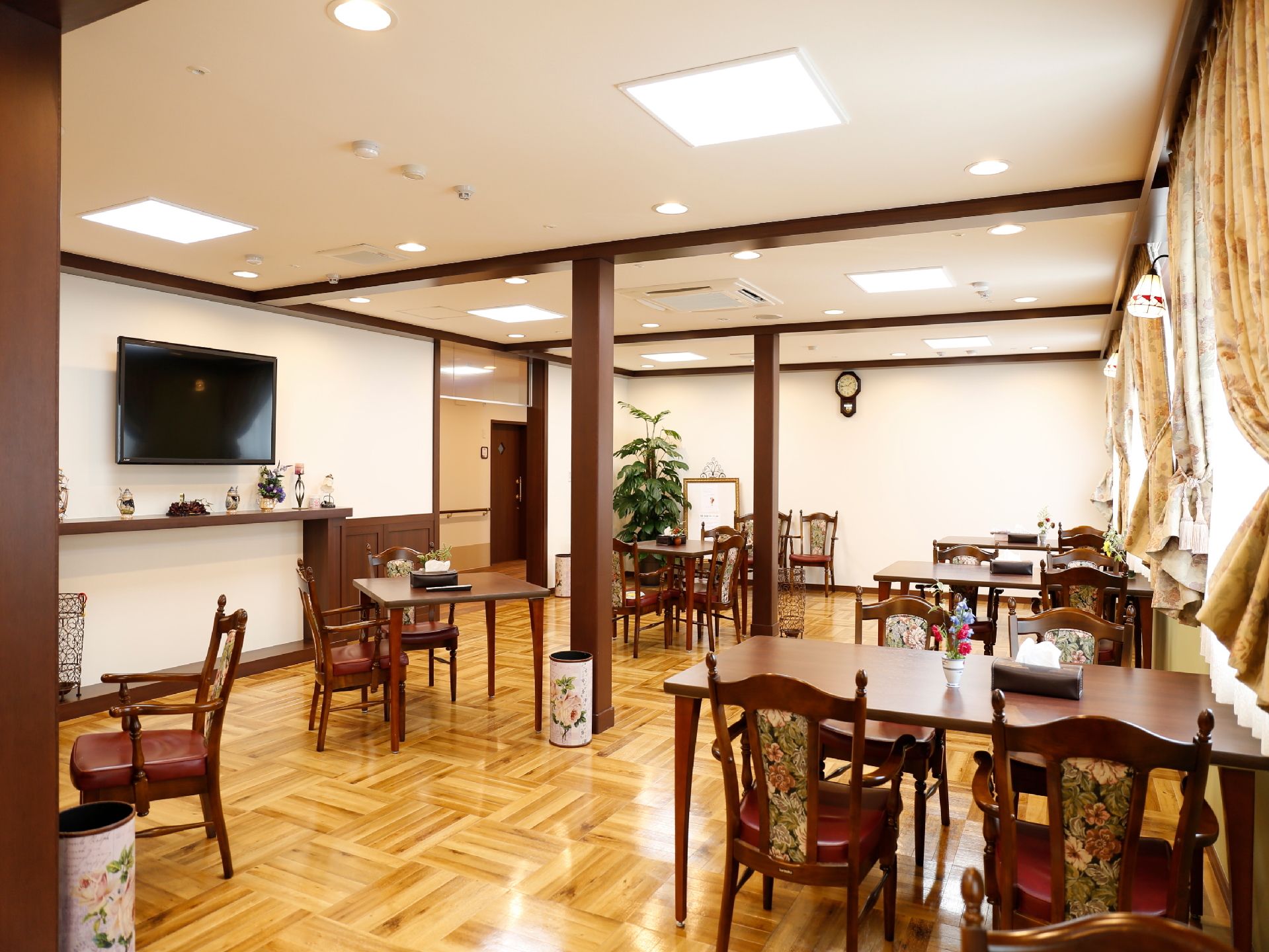 シックな家具が落ち着いた印象を与える場所。沢山の窓から光も入って明るく、天井の高さも居心地の良い空間。
