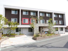 建物は白と茶色の外壁の一部に赤のポイントが入ったスタイリッシュなデザイン。車から降りてスムーズに入れるように、玄関前に車寄せを設けている。