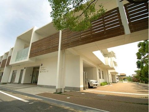 白とブラウンの外観で、緑の木々や植物と調和した当施設は心豊かにゆったりとお過ごしいただけるよう配慮している。