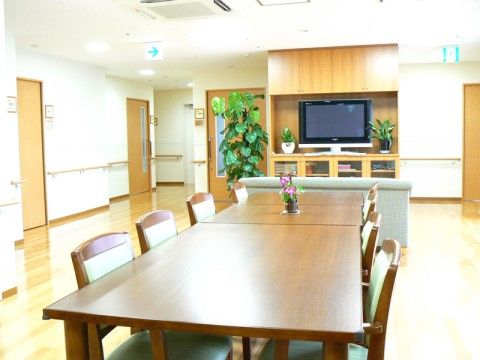 椅子やテーブルが設置されたリビングは、テレビや観葉植物が置かれており入居者様同士で談話やテレビを見る時間などをお楽しみいただける。