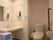 車椅子でも入れる広さのあるトイレは、介助の方とも入れる。清潔感あるオフホワイトで統一され、明るく安全。