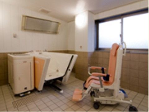タイル張りの浴室に、車椅子に乗ったまま浴槽に入ることができる特殊な浴槽が設置されている。暖房設備も完備している。