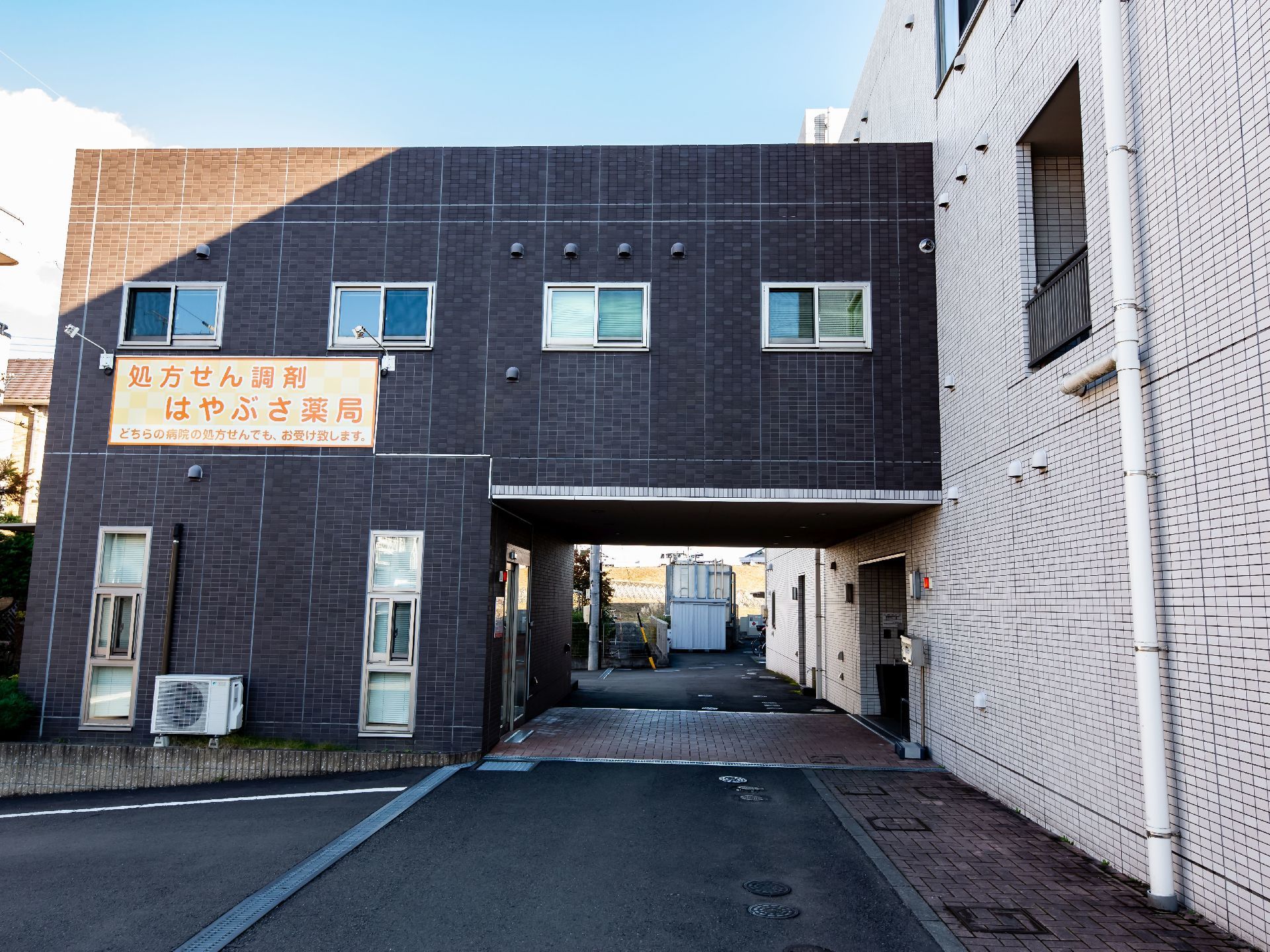 ダークブラウンと白のタイル調の外壁である。同じ建物内に薬局があり、雨の日も濡れることなく移動が行える造りになっている。