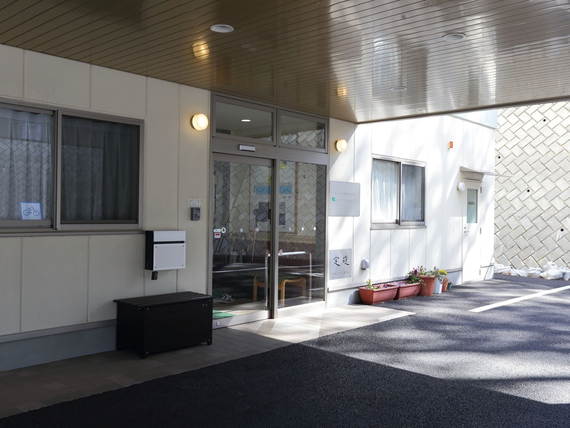 玄関には、屋根のついた乗降スペースが用意されている。また入り口の壁には、郵便受けが取り付けられている。